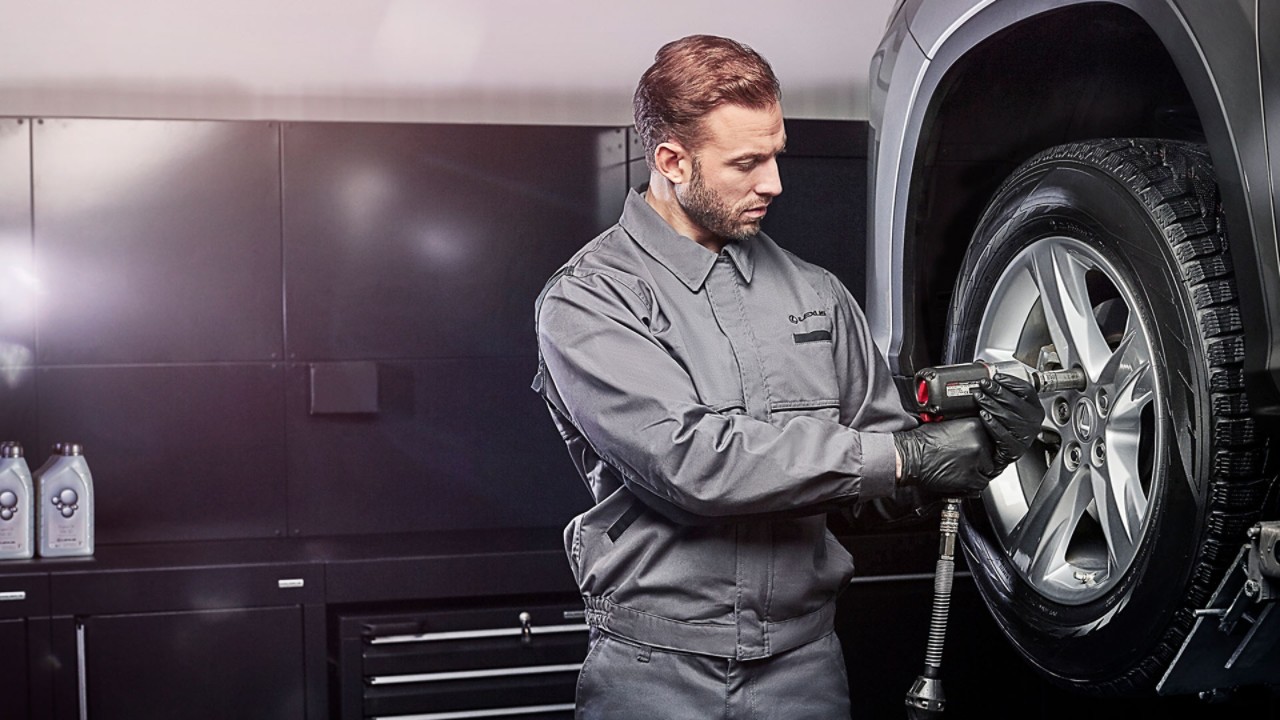 A mechanic next to a Lexus 