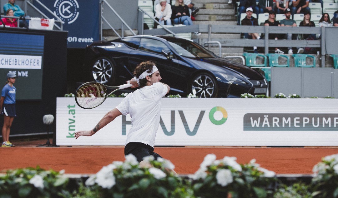 Roger Federer on a tennis court with a Lexus in the background
