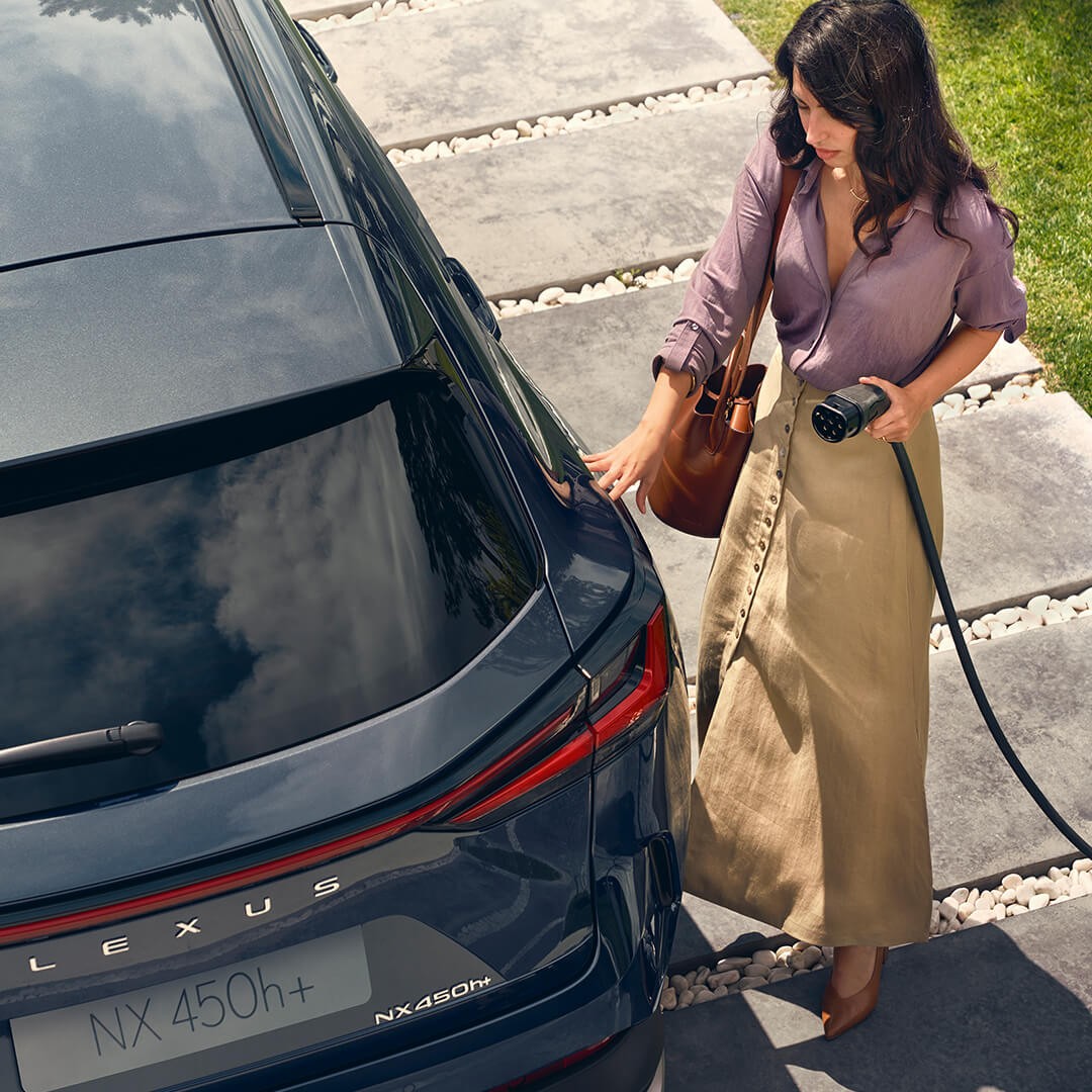 A woman plugging in a Lexus NX 